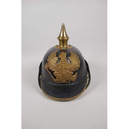 223 - A reproduction German pickelhaube with brass mounts