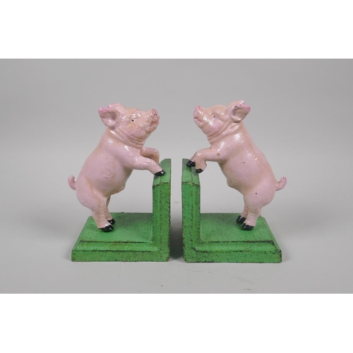 228 - A pair of painted cast iron pig bookends, 14cm high, and a painted cast iron pig money box