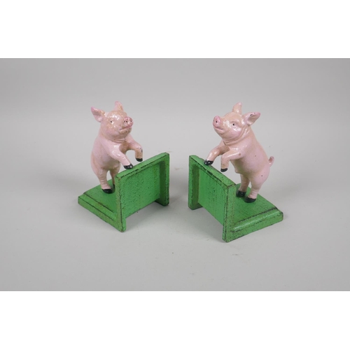 228 - A pair of painted cast iron pig bookends, 14cm high, and a painted cast iron pig money box