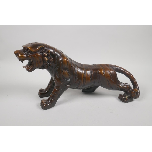 230 - A filled bronze figure of a tiger, 32cm long