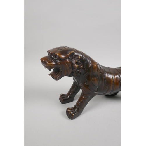 230 - A filled bronze figure of a tiger, 32cm long