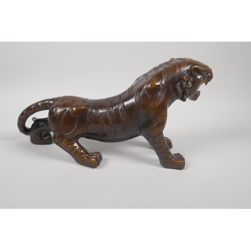 230 - A filled bronze figure of a tiger, 32cm long