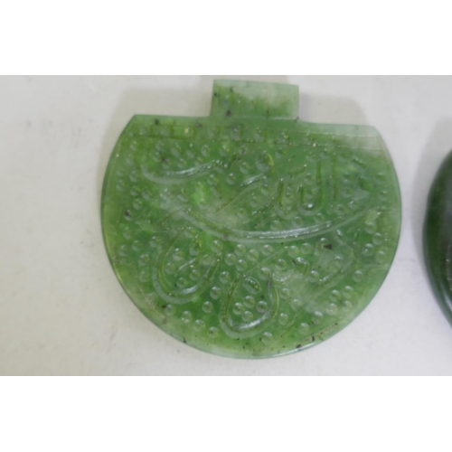 256 - Two jade pendants carved with Islamic calligraphy, 6cm wide