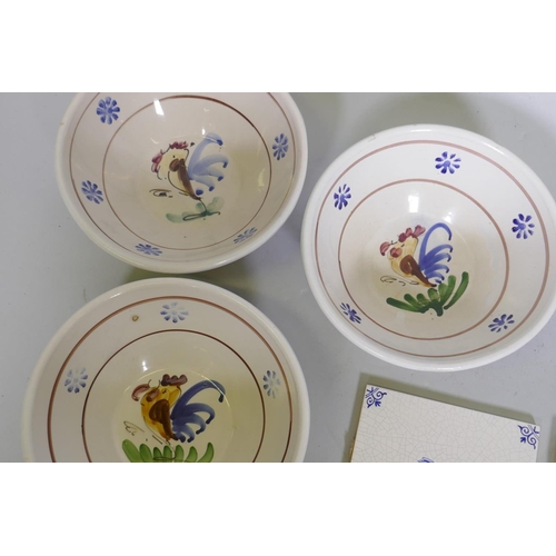 37 - Collection of continental faience tiles and three bowls decorated with cockerels, 19cm diameter