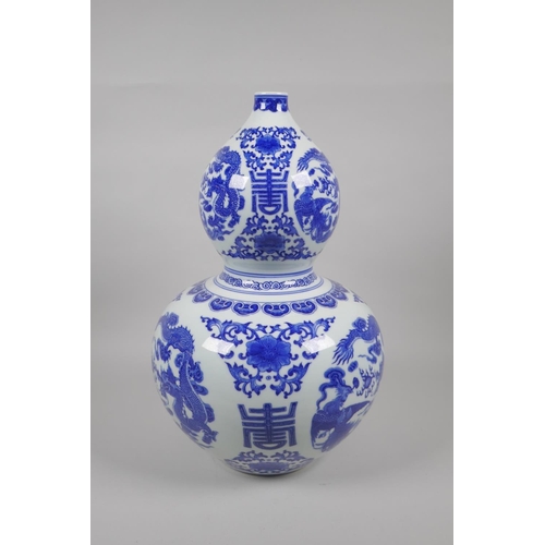 48 - A Chinese blue and white porcelain double gourd vase, decorated with dragons, phoenix, flowers and a... 