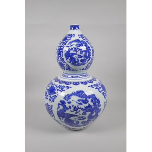 48 - A Chinese blue and white porcelain double gourd vase, decorated with dragons, phoenix, flowers and a... 