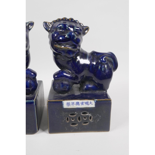 52 - A pair of Chinese deep blue glazed porcelain fo-dogs on plinths, Xuande 6 character mark to side, 22... 