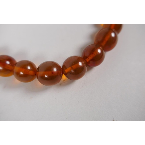 602 - A graduated honey amber bead necklace, 26cm, 55g