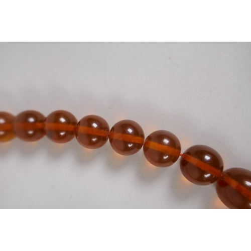 602 - A graduated honey amber bead necklace, 26cm, 55g