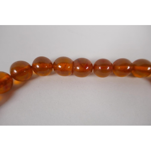 602 - A graduated honey amber bead necklace, 26cm, 55g