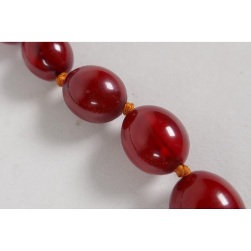 605 - A graduated honey amber bead necklace with 9ct gold clasp, 40cm long, 50g