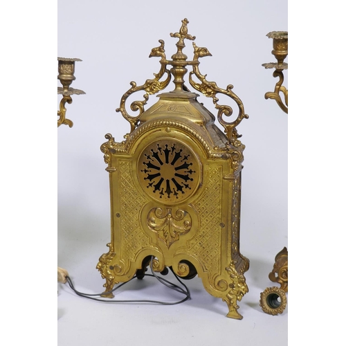 606 - A C19th gilt brass clock garniture, the clock with electric movement flanked by a pair of four branc... 