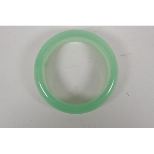 608 - A celadon jadeite bangle, 8cm diameter