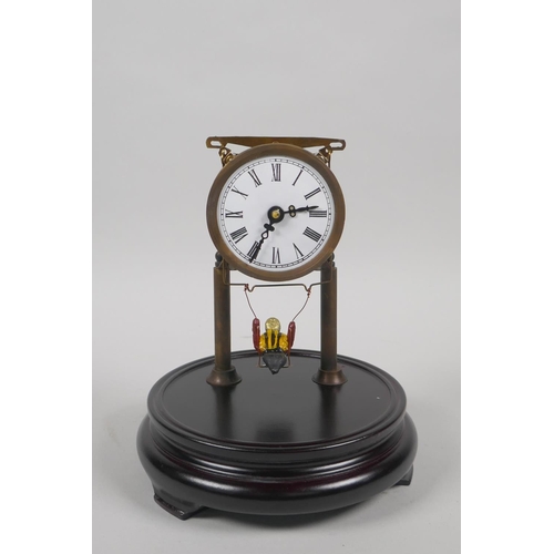 609 - A glass domed skeleton clock, the pendulum in the form of a child on a swing, 21cm high