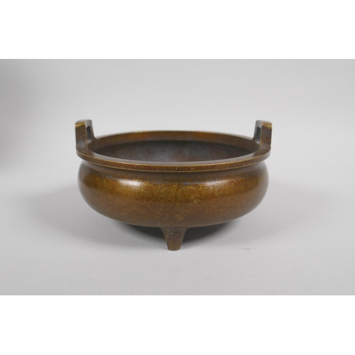 63 - A Chinese bronze two handled censer on tripod supports, 6 character mark to base, 15cm diameter