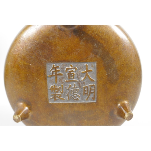 63 - A Chinese bronze two handled censer on tripod supports, 6 character mark to base, 15cm diameter