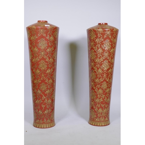 64 - A pair of oriental ceramic floor vases with raised decoration on a red glaze, 63cm high