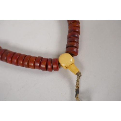 645 - A string of faux horn Tibetan mala beads with brass vajra feature beads, 60cm