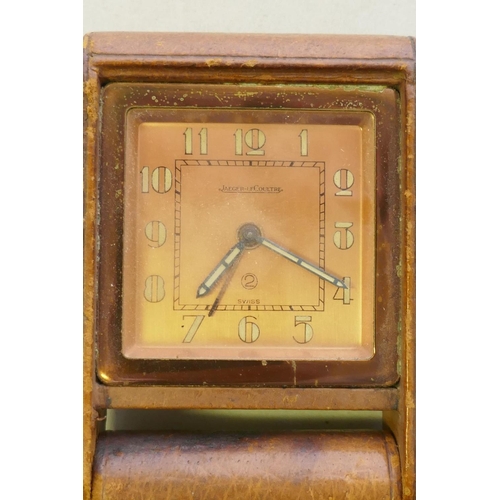 655 - A Jaeger-leCoutre travelling alarm clock, with rose coloured dial, luminescent numerals and hands, a... 