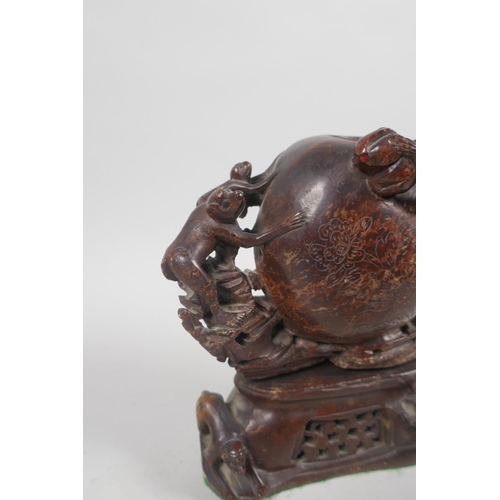 68 - An antique Chinese carved soapstone pot in the form of a peach with climbing monkeys, 17cm high