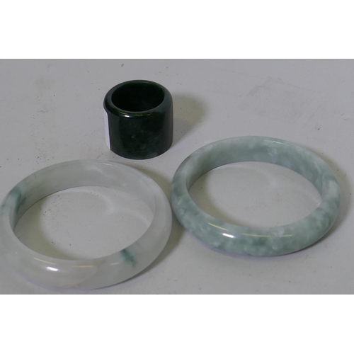 73 - Two mottled celadon jade bangles, 5.5cm internal diameter, and a spinach jade archer's ring