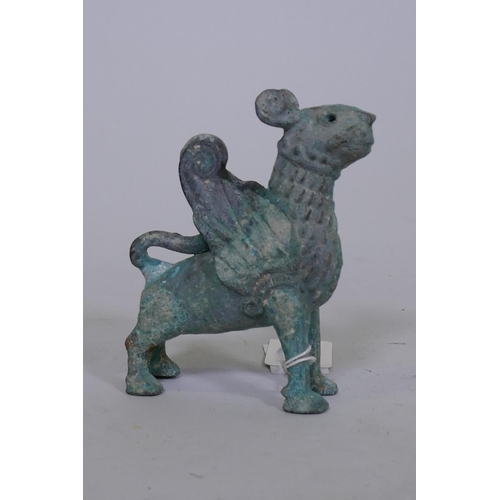 81 - A Middle Eastern verdigris bronze figure of a winged lion, 10.5cm high