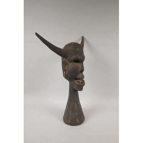 89 - A carved and painted tribal head bust of a horned deity, 44cm high