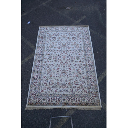 1064 - An ivory ground Kashmir rug with all over floral design, 156 x 234cm