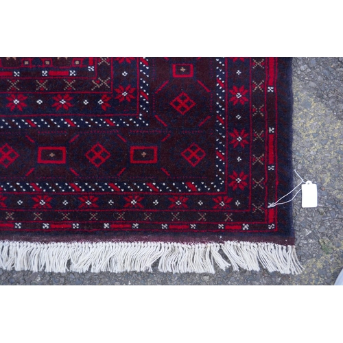 1065 - A fine hand woven burgundy ground full pile Afghan balouch nomadic rug, 118 x 186cm