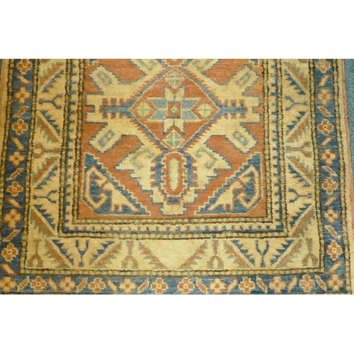 1076 - A hand woven wool Kazak runner with repeating design on a buff coloured field, 400 x 84cm