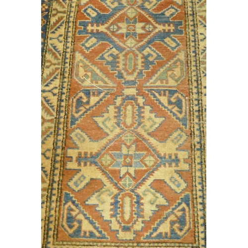 1076 - A hand woven wool Kazak runner with repeating design on a buff coloured field, 400 x 84cm