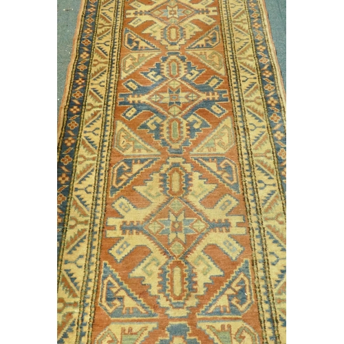 1076 - A hand woven wool Kazak runner with repeating design on a buff coloured field, 400 x 84cm