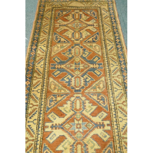 1076 - A hand woven wool Kazak runner with repeating design on a buff coloured field, 400 x 84cm