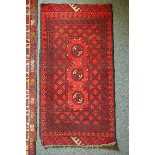 1101 - A red ground oriental carpet with a Chinese willow pattern design, and an Afghan red ground prayer m... 