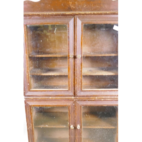 1151 - A C19th stained pine shop cabinet, two pairs of glazed doors over a single drawer, 87 x 29 x 153cm