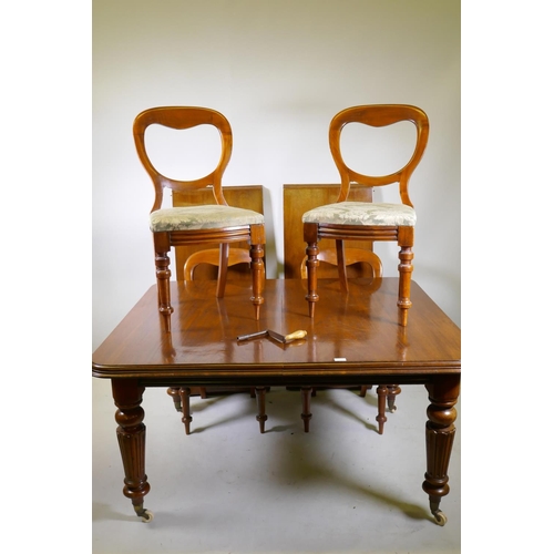 1166 - A Victorian mahogany windout dining table with two extra leaves, raised on turned and fluted support... 