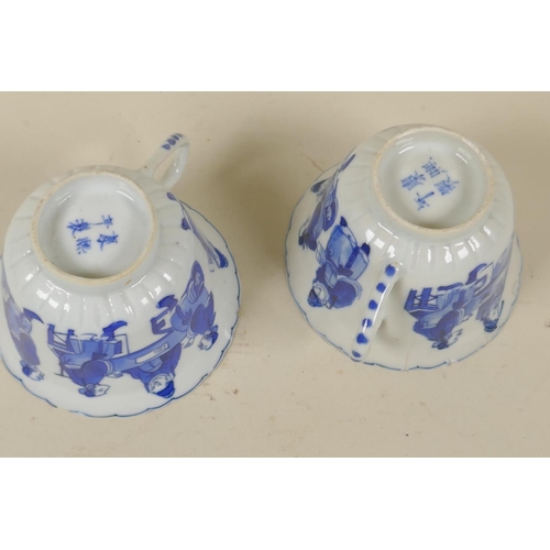 14 - Pair of Chinese blue and white porcelain tea cups, decorated with men eating and gaming, KangXi mark... 