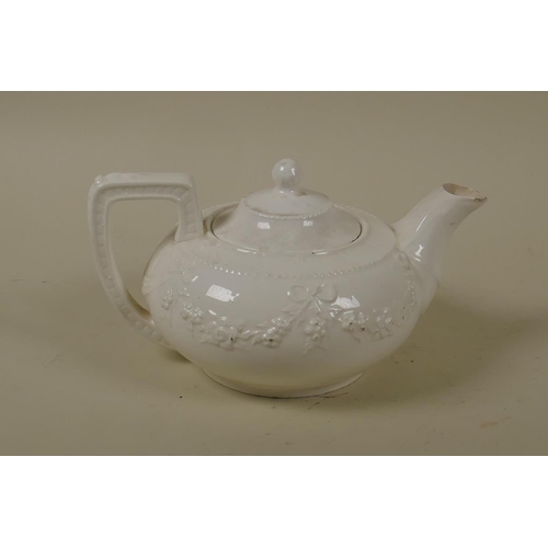 25 - A C19th Staffordshire creamware tea pot with raised swag and bow decoration, 10cm high