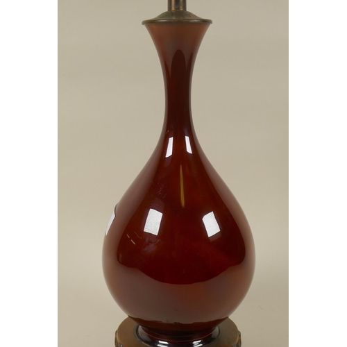 31 - An Oriental style sang de boeuf glaze ceramic vase lamp with metal mount and pierced metal base, 52c... 