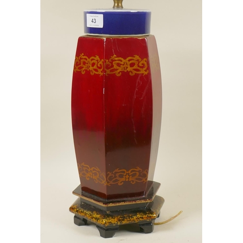 43 - An Oriental red lacquered table lamp with ceramic top, 70cm high