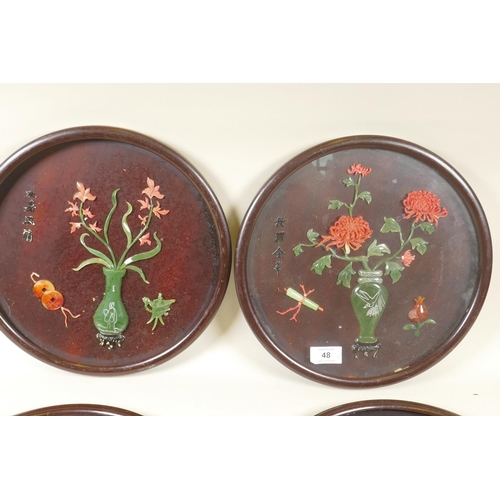 48 - Four Chinese lacquered roundel plaques with raised decoration, AF, 32cm diameter