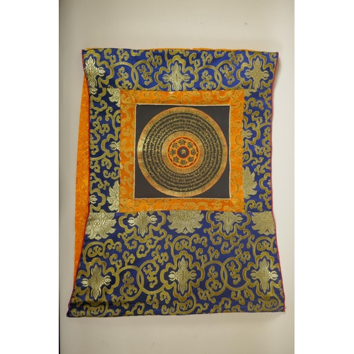 71 - A Tibetan hand painted mandala within a silk mount, 48 x 62cm