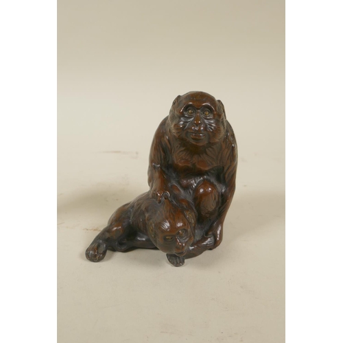 80 - A Japanese bronzed metal okimono of monkeys, 10cm high, and a primitive carved bone figure