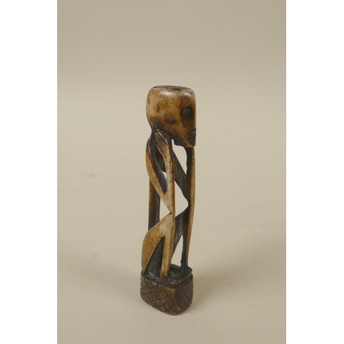 80 - A Japanese bronzed metal okimono of monkeys, 10cm high, and a primitive carved bone figure