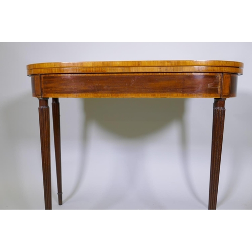 1007 - A Georgian mahogany D shaped card table, with cross banded top and frieze, raised on reeded tapering... 