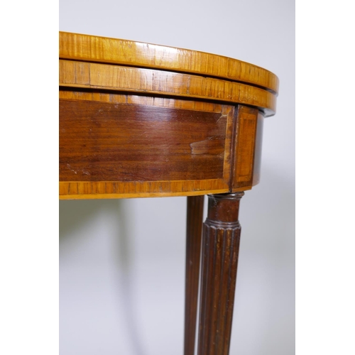 1007 - A Georgian mahogany D shaped card table, with cross banded top and frieze, raised on reeded tapering... 