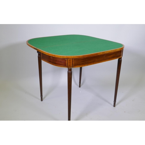 1007 - A Georgian mahogany D shaped card table, with cross banded top and frieze, raised on reeded tapering... 