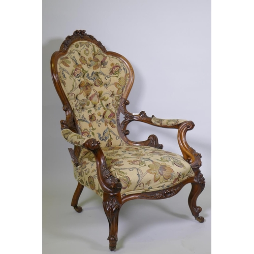 1012 - A good Victorian shaped back walnut show frame armchair with finely carved floral and scroll decorat... 