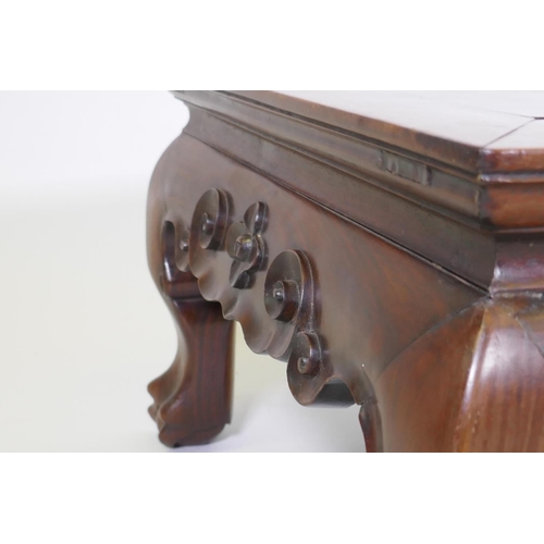 1014 - A Chinese rosewood low table, with inset panel top and finely carved scrolled frieze, raised on shap... 