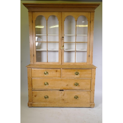 1018 - Victorian stripped pine dresser/display cabinet, the upper section with a pair of arched glazed door...